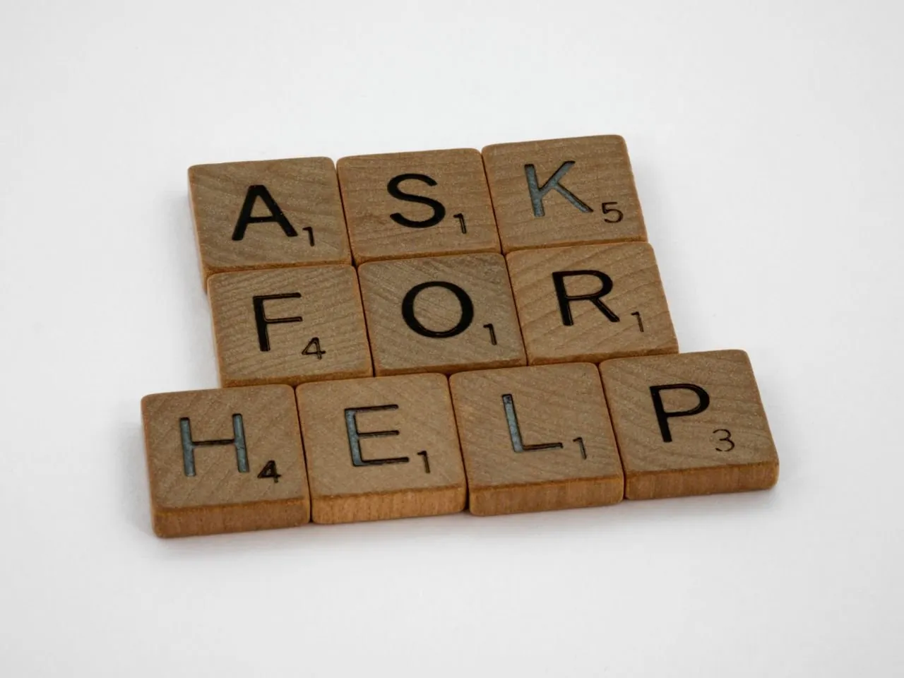 Wooden letter tiles spelling ‘Ask for help’