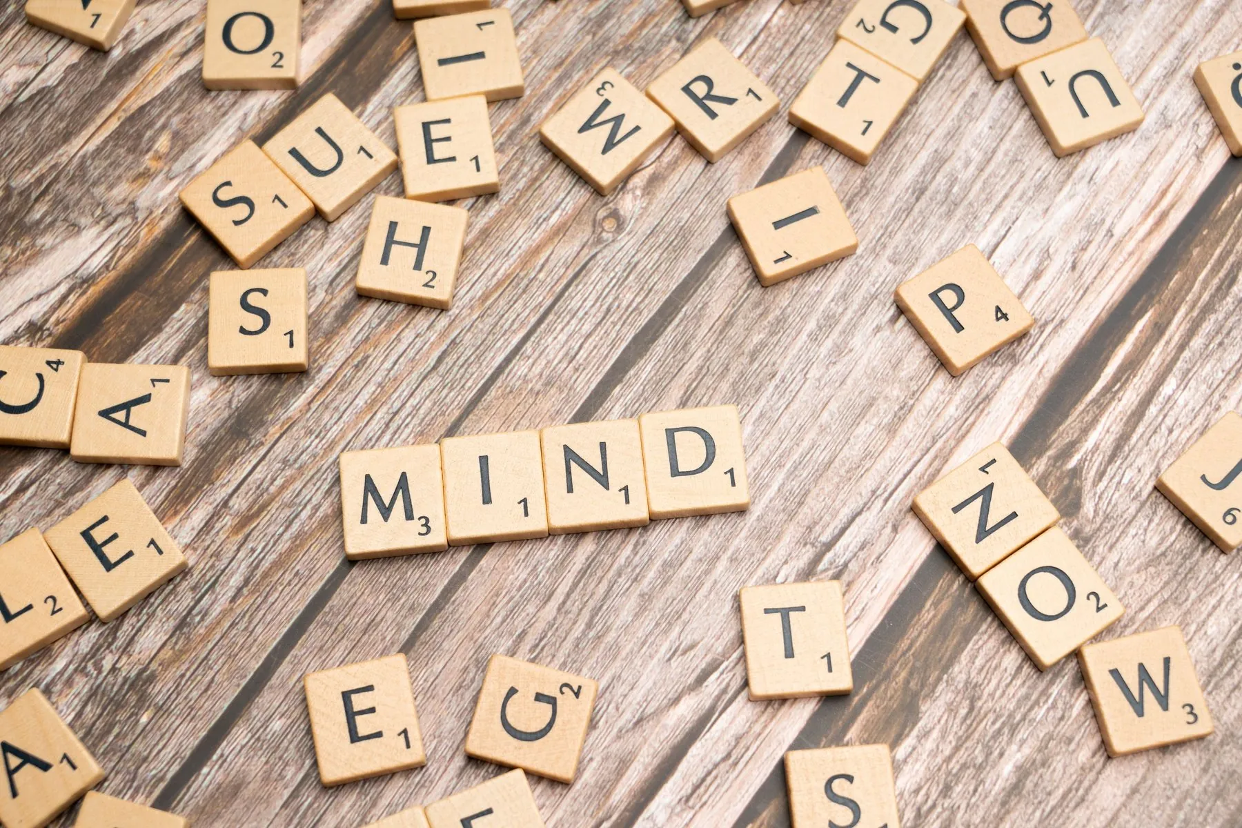 Wooden letter tiles spelling the word MIND